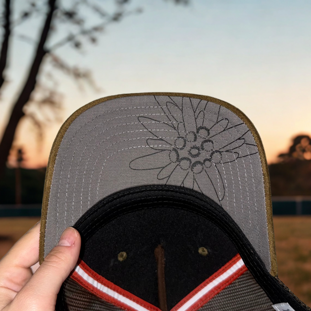 Österreichische Trucker Cap – Undervisor mit Edelweiß-Blumen-Motiv in Nahaufnahme, mit Austria Flagge