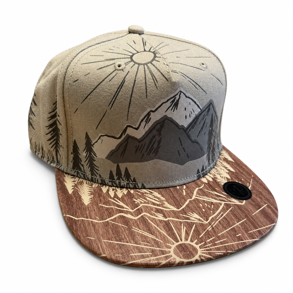 Tirol-Cap mit Berg-, Wald- und Sonnenmotiv sowie flachem Furnierschirm auf weißem Hintergrund.